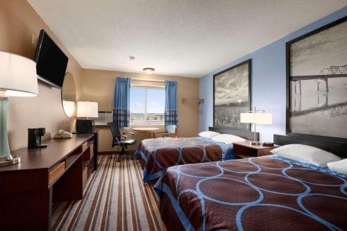 a hotel room with two beds and a desk at Super 8 by Wyndham Council Bluffs IA Omaha NE Area in Council Bluffs