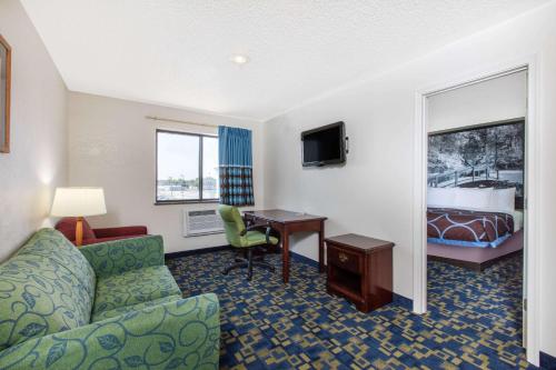a hotel room with a couch and a desk and a bed at Super 8 by Wyndham Aberdeen MD in Aberdeen