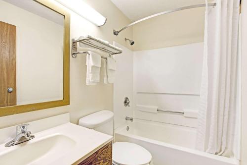 Baño blanco con lavabo y aseo en Super 8 by Wyndham Baltimore/Essex Area, en Essex