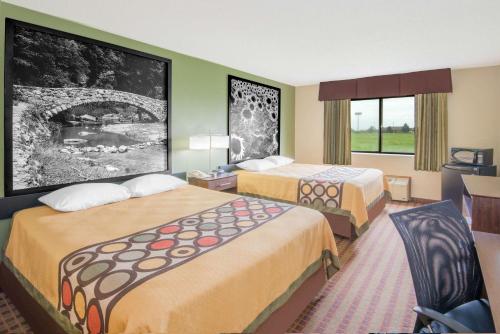 a hotel room with two beds and a desk at Super 8 by Wyndham Story City in Story City