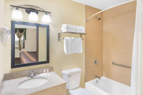 a bathroom with a sink and a toilet and a mirror at Super 8 by Wyndham Webster City IA in Webster City