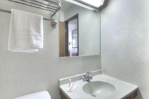 a bathroom with a sink and a mirror and a toilet at Super 8 by Wyndham Augusta in Augusta
