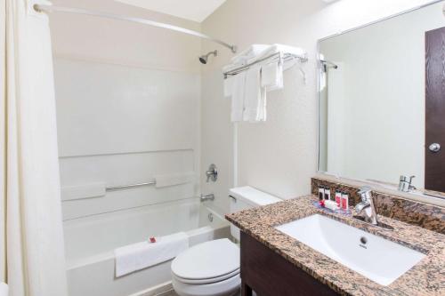 a bathroom with a sink and a toilet and a mirror at Super 8 by Wyndham Aberdeen MD in Aberdeen