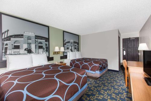 a hotel room with two beds and a desk at Super 8 by Wyndham Aberdeen MD in Aberdeen
