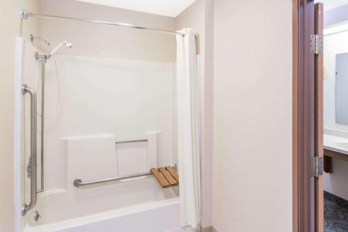 a bathroom with a shower with a white tub at Super 8 by Wyndham Dodgeville in Dodgeville