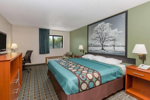 a hotel room with a bed and a television at Super 8 by Wyndham Osceola IA in Osceola