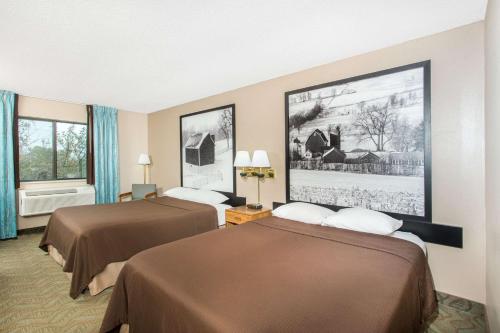 a hotel room with two beds and two windows at Super 8 by Wyndham Dodgeville in Dodgeville