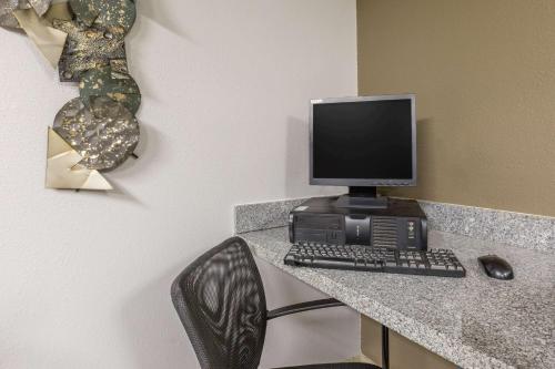 a desk with a computer monitor and a keyboard and mouse at Super 8 by Wyndham Osceola IA in Osceola
