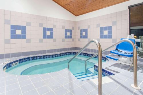 a swimming pool with a hot tub in a bathroom at Super 8 by Wyndham Dodgeville in Dodgeville