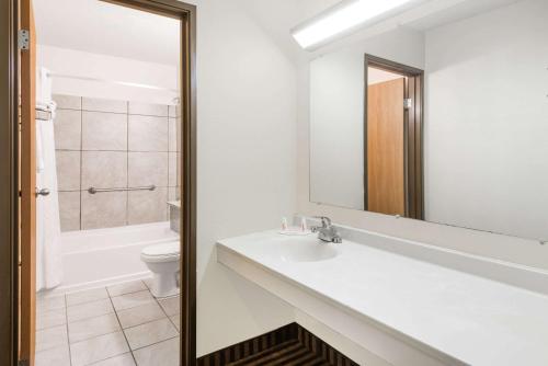 a bathroom with a sink and a toilet and a mirror at Super 8 by Wyndham La Vale/Cumberland Area in La Vale