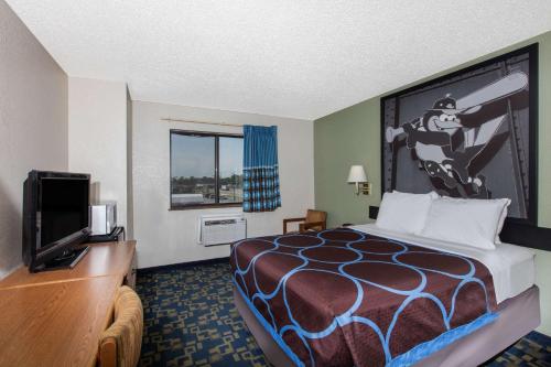 a hotel room with a bed and a flat screen tv at Super 8 by Wyndham Aberdeen MD in Aberdeen