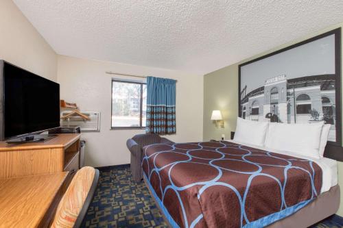 a hotel room with a bed and a flat screen tv at Super 8 by Wyndham Aberdeen MD in Aberdeen