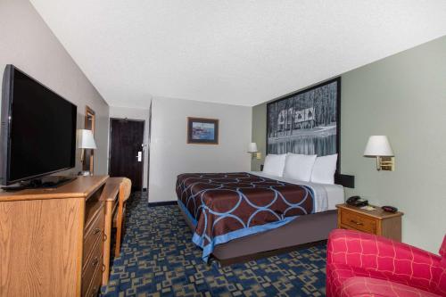 a hotel room with a bed and a flat screen tv at Super 8 by Wyndham Aberdeen MD in Aberdeen
