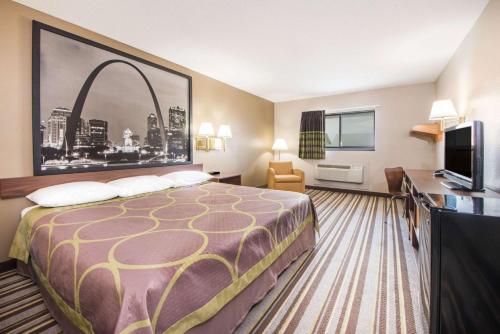 a hotel room with a bed and a television at Super 8 by Wyndham Nevada in Nevada
