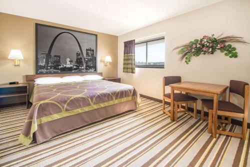 a hotel room with a bed and a table and chairs at Super 8 by Wyndham Nevada in Nevada