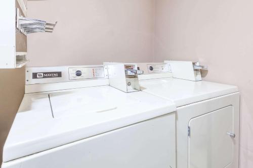 a white laundry room with a washer and dryer at Super 8 by Wyndham Imlay City in Imlay City
