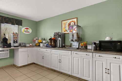 a kitchen with white cabinets and a microwave at Quality Inn in Jackson