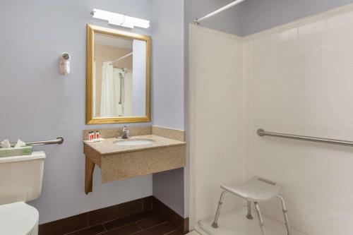 a bathroom with a sink and a toilet and a mirror at Super 8 by Wyndham Havre De Grace Aberdeen Area in Havre de Grace