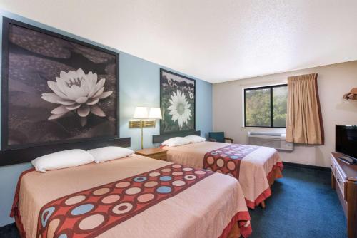 a hotel room with two beds and a television at Super 8 by Wyndham Thurmont in Thurmont