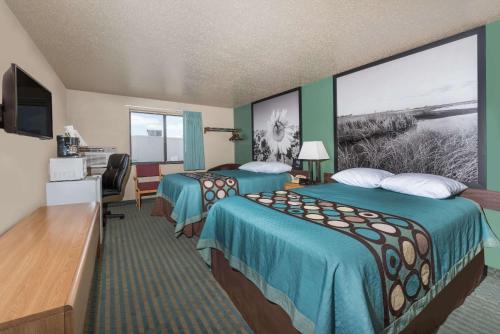 a hotel room with two beds and a large window at Super 8 by Wyndham Devils Lake in Devils Lake