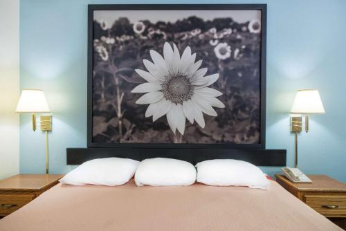 a painting of a flower above a bed with two pillows at Super 8 by Wyndham Thurmont in Thurmont