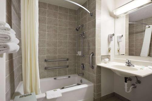 a bathroom with a sink and a tub and a toilet at Super 8 by Wyndham Peru Starved Rock State Park in Peru