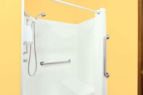 um chuveiro com uma cortina de chuveiro branca na casa de banho em Super 8 by Wyndham Mitchell em Mitchell