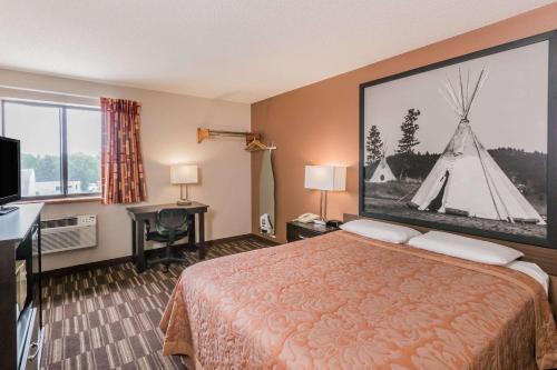 une chambre d'hôtel avec un lit et une grande photo dans l'établissement Super 8 by Wyndham Madison, à Madison