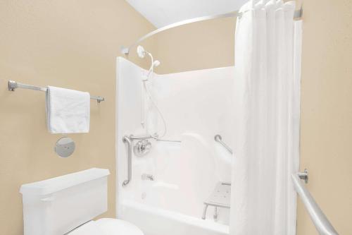 a bathroom with a shower and a white toilet at Super 8 by Wyndham East Moline in East Moline