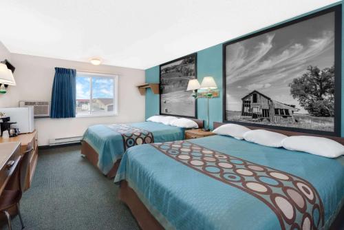a hotel room with two beds and a black and white photo at Super 8 by Wyndham Huron in Huron