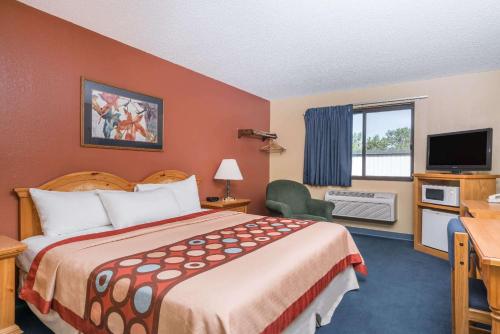 a hotel room with a bed and a television at Super 8 by Wyndham Baxter/Brainerd Area in Baxter