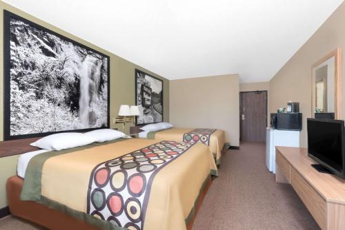 a hotel room with two beds and a flat screen tv at Super 8 by Wyndham Winner SD in Winner