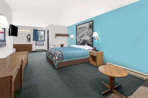 a hotel room with a bed and a desk at Super 8 by Wyndham Huron in Huron