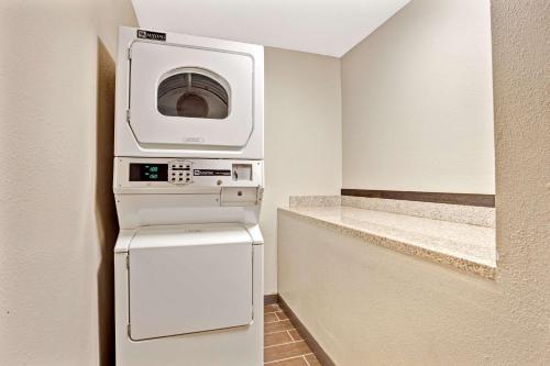 a kitchen with a microwave and a washer and dryer at Super 8 by Wyndham Louisville Airport in Louisville