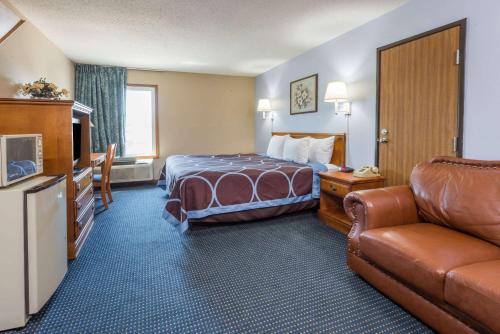 a hotel room with a bed and a couch at Super 8 by Wyndham O'Fallon MO/St. Louis Area in O'Fallon