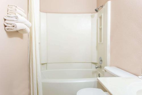 a bathroom with a tub and a toilet and a sink at Super 8 by Wyndham Austin MN in Austin