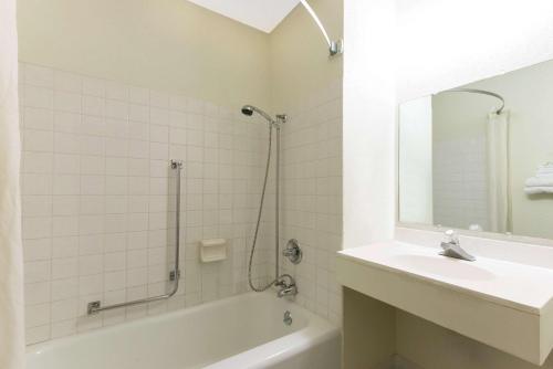 y baño con bañera, lavabo y espejo. en Super 8 by Wyndham Raton, en Ratón