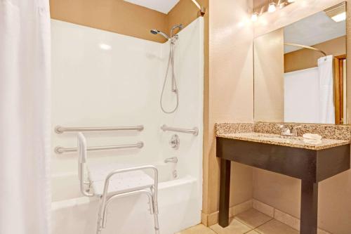 a bathroom with a shower and a sink and a tub at Super 8 by Wyndham Louisville Airport in Louisville