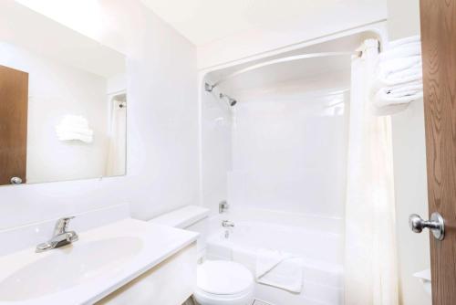 bagno bianco con lavandino e servizi igienici di Super 8 by Wyndham Belle Fourche SD a Belle Fourche