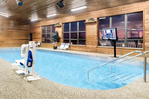 a large swimming pool with a basketball hoop in a building at Super 8 by Wyndham Chamberlain SD in Chamberlain