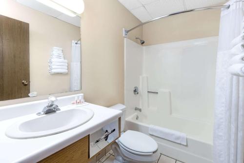 a bathroom with a sink and a toilet and a mirror at Super 8 by Wyndham Chamberlain SD in Chamberlain