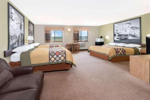 a hotel room with two beds and a couch at Super 8 by Wyndham Winner SD in Winner