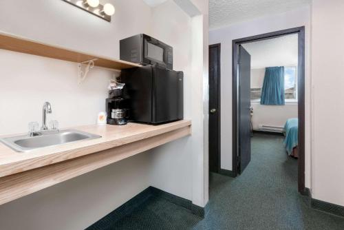a bathroom with a sink and a microwave at Super 8 by Wyndham Huron in Huron
