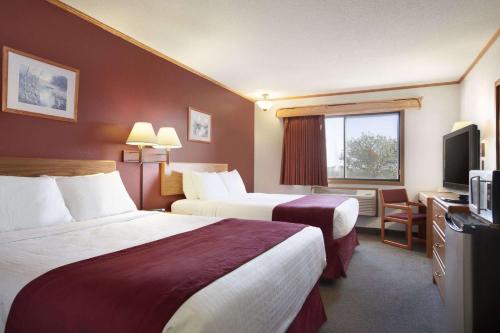 a hotel room with two beds and a television at Super 8 by Wyndham Eveleth in Eveleth