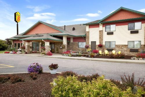 a front view of a hotel with flowers at Super 8 by Wyndham Eveleth in Eveleth