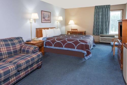 a hotel room with a bed and a couch at Super 8 by Wyndham O'Fallon MO/St. Louis Area in O'Fallon