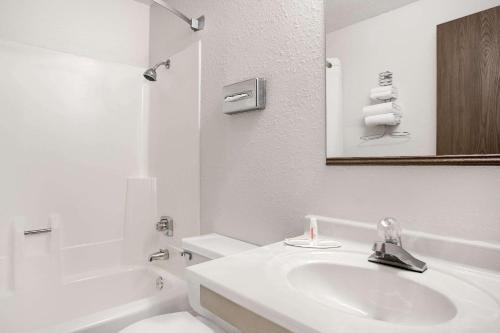 Baño blanco con lavabo y aseo en Super 8 by Wyndham Willmar en Willmar