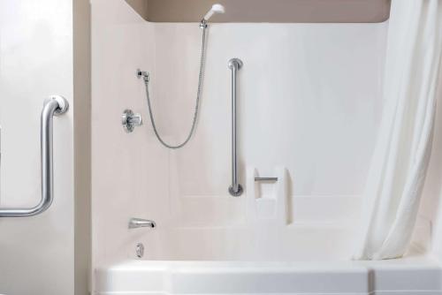 La salle de bains est pourvue d'une douche et d'une baignoire blanche. dans l'établissement Super 8 by Wyndham Mankato, à Mankato
