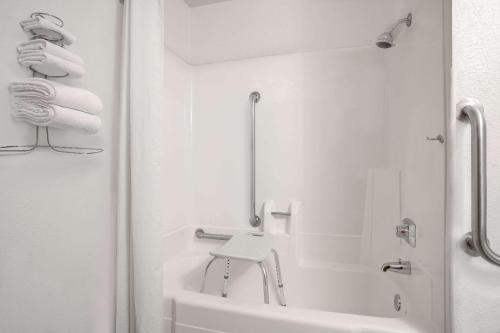a white bathroom with a sink and a bath tub at Super 8 by Wyndham Willmar in Willmar