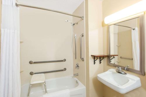 a white bathroom with a sink and a mirror at Super 8 by Wyndham Fairmont in Fairmont